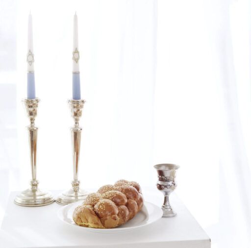 Table with Silver Candle Stands Beside Wine Chalice and Loaf of Bread